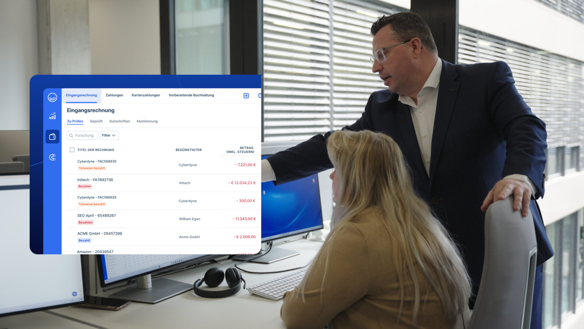 Ein Mann und eine Frau arbeiten bei Agicap zusammen. Der Mann zeigt auf einen Bildschirm