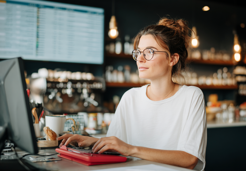Mann erstellt eine Rechnung am Laptop mit easybill, Benutzeroberfläche zur Rechnungserstellung sichtbar.